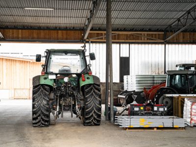 Modern,Green,Good-looking,Tractor,Stands,In,Outside,Garage,Near,Agricultural